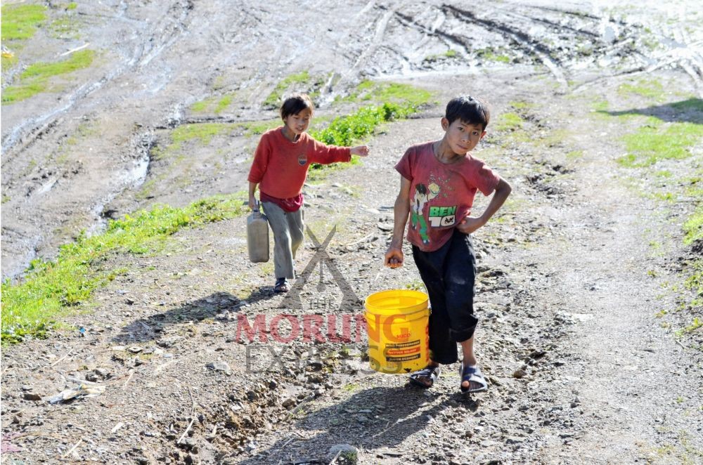 Two children collect water in buckets at Chendang village in Tuensang district. (Morung Photo by Moses Hongang Chang)